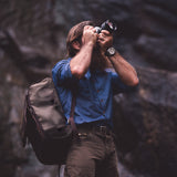 Man taking pictures with. a camera bag over the shoulder.